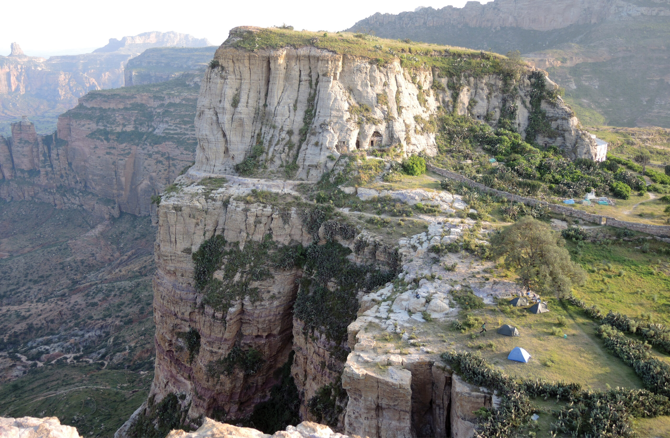 Above A large number of churches are built into the cliffs in the northern Ethiopian province of Tigray. Here we look down over the site of the hermit cave church of Daniel Qorqor and its larger neighbour, the church of Maryam Qorqor. The modern-built facade of the church is visible just at the right edge of the cliff.