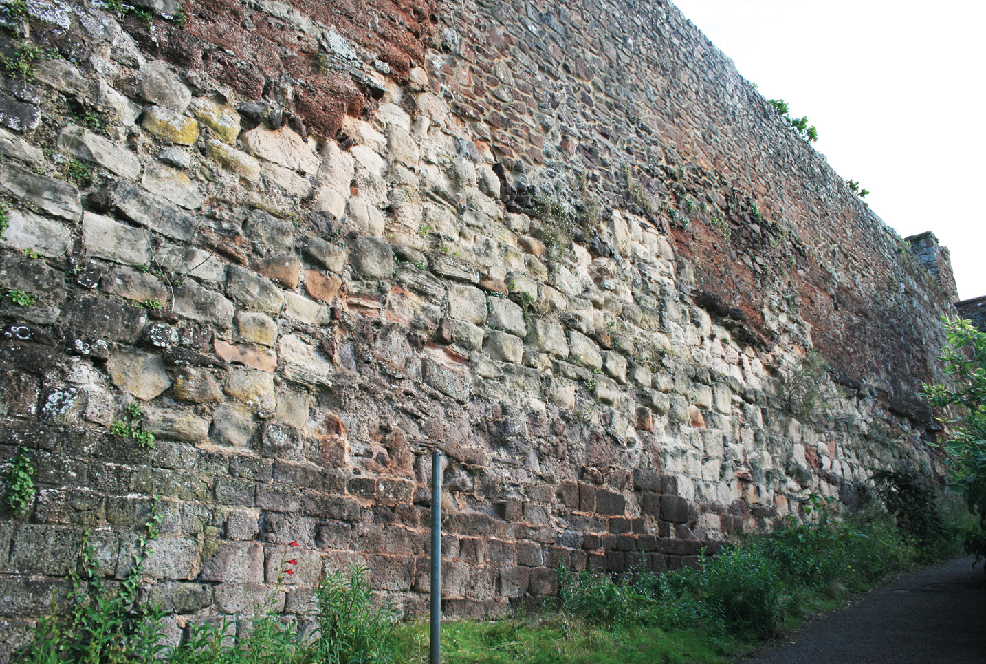 BELOW The city wall in Northernhay Gardens, showing Roman, late Saxon, Norman, and later masonry. The late Saxon crenellations in white sandstone are infilled with later masonry.