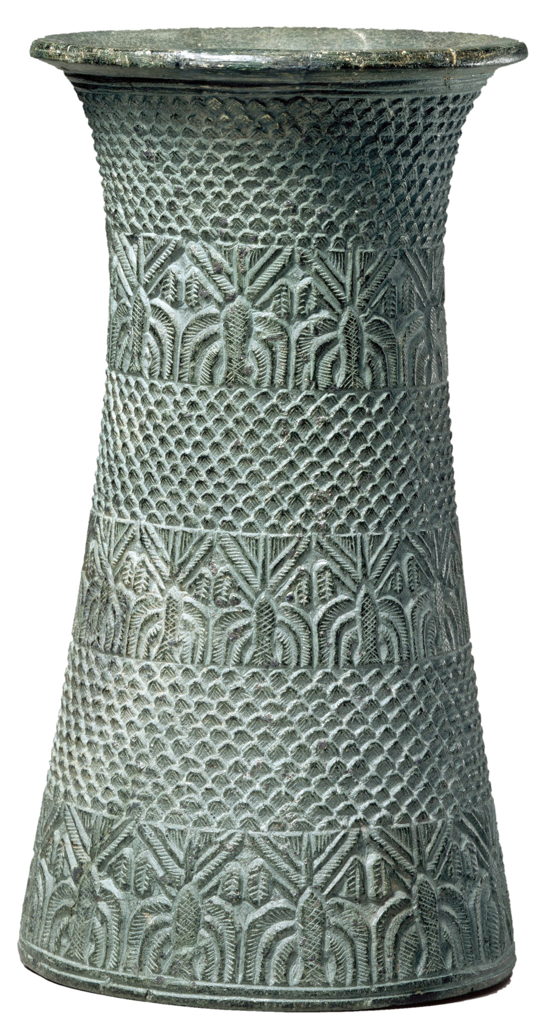 left Elamite group of two figures, perhaps a royal couple. Bronze, 1500-1100 BC. Size: 16 x 13.5cm right Vase with carved decorations showing date palms and bands of a pattern sometimes thought to represent mountains. Chlorite, c.2500 BC. Size: 23.5cm high