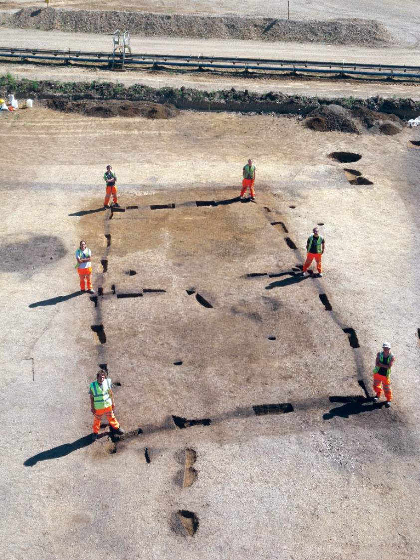 RIGHT The footprint of the original house measured 15m by 7.5m, but this substantial structure seems to have been built around just six post-holes (each marked here by a member of Wessex Archaeology).