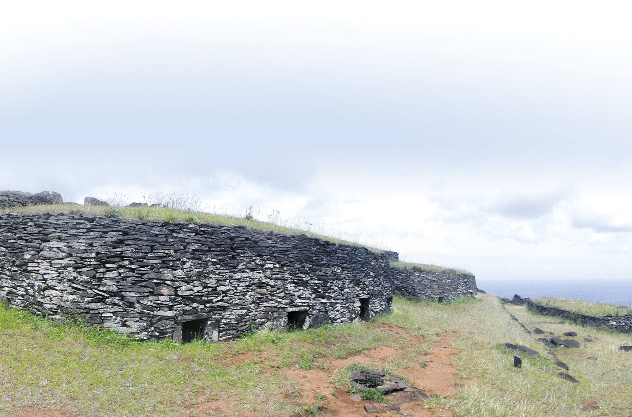 below Stone houses of Orongo village, constructed of dry-laid basalt slabs. The foreground four-entrance house, called Taura Renga, once sheltered the moai called Hoa Hakananai'a.