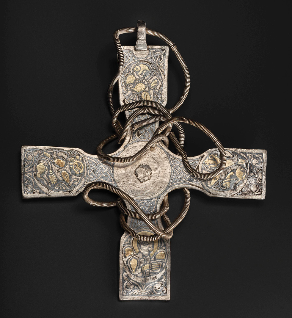 ABOVE Christian objects like this pectoral cross are rare finds in Viking Age hoards. It is wrapped in the slender chain on which it would have been worn, and its Trewhiddle-style decorations suggest it is late Anglo-Saxon.