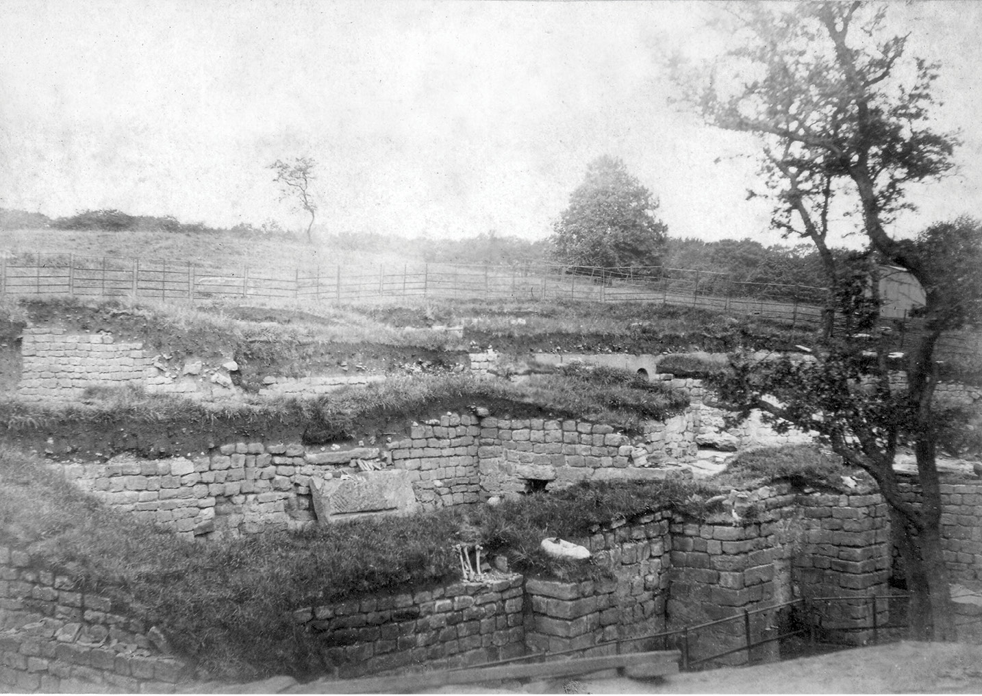 below A photograph of the bathhouse at Chesters fort, taken during excavations in 1885. In the foreground is the outer wall of a hot room, with human bones lying on it. Did these come from a cemetery beyond the bathhouse walls?