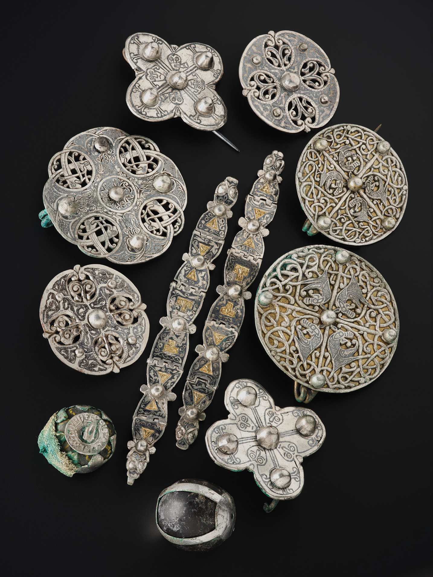 RIGHT A lidded vessel contained a host of unusual objects, including these Anglo-Saxon brooches and straps, as well as unusual pendants of glass and rock crystal. Anglo-Saxon metalwork is rarely found in Scotland, and many of the designs within the vessel are unique.