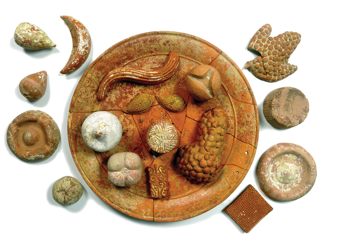 below Food played an important part in funerary customs in ancient Italy. This plate of terracotta votive food (including open and closed pomegranates, grapes, figs, honeycombs, cheeses, and breads) was found in a 360 BC tomb in Paestum.