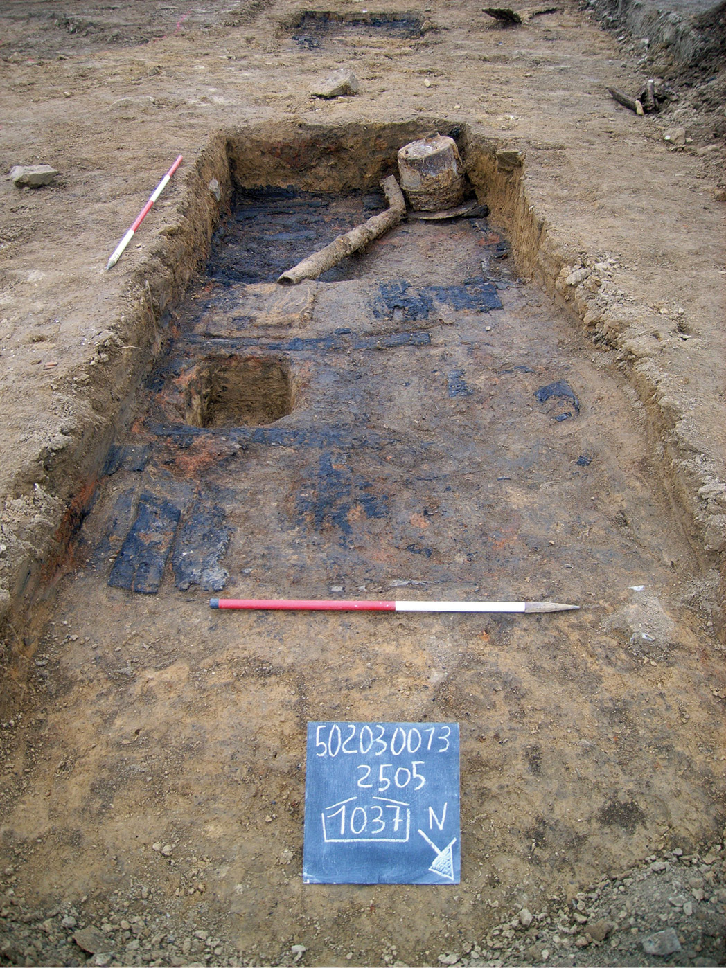 Above A German marine’s uniform button. left One of the sunken structures with the stove and some of the pipe flue visible. Note the burnt soil, probably due to the building's destruction