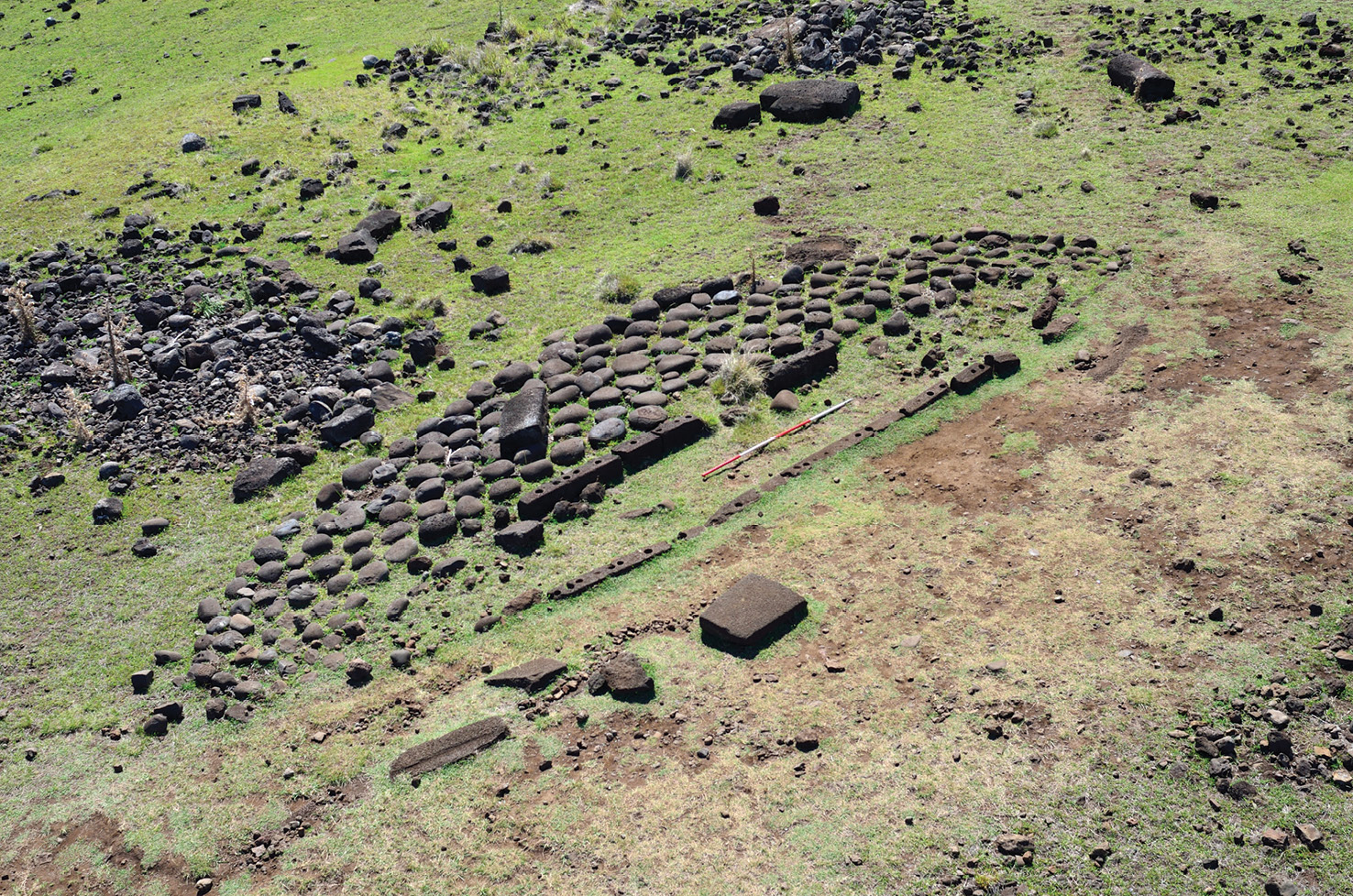 BELOW Hare paenga at Akahanga: these canoe-shaped houses can be identified by the long black basalt slabs with circular holes carved into their tops, and the semicircle of poro water-worn stones that provides a platform outside the door.