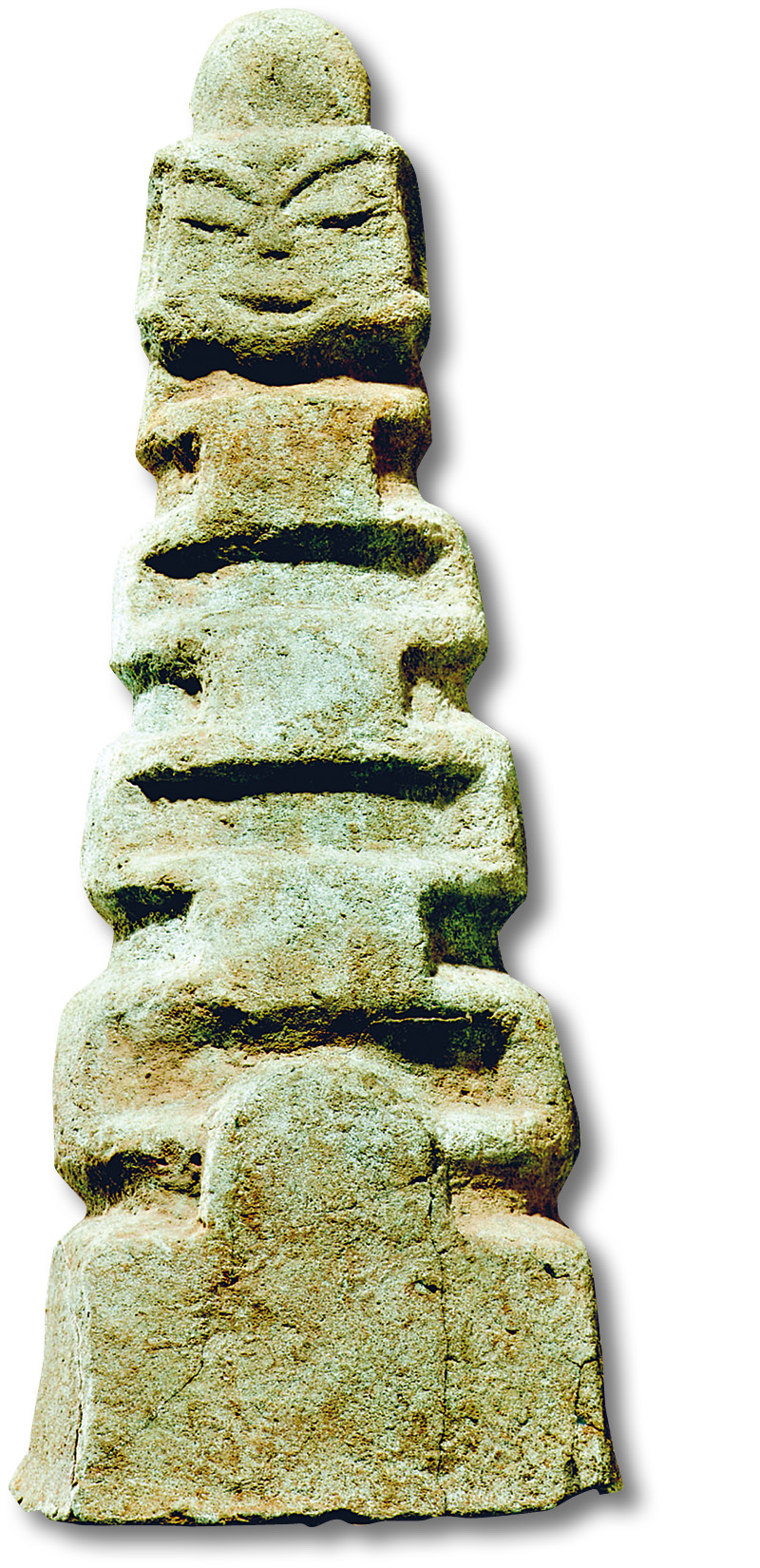 below A full-round, green-metal figure resembling a tower-temple with a Kala head on the doorway.
