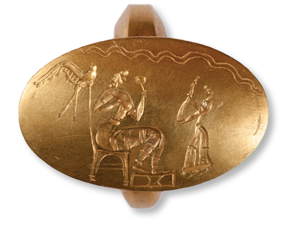 top Goddess, seated at the left, holding a mirror. A bird sits on her throne, behind the goddess's head. A worshipper approaches on the right, carrying a curved object that is likely to be a horn. above Gold ring with Minoan cult scene focused on a small shrine flanked by date palms. To the left is a goddess who dances with two young acolytes. To the right, two women with conical hats sing. The ornate shank of the ring (top Right), unlike the simpler styles of the others, shows strong similarities with two other rings previously found in Greece.