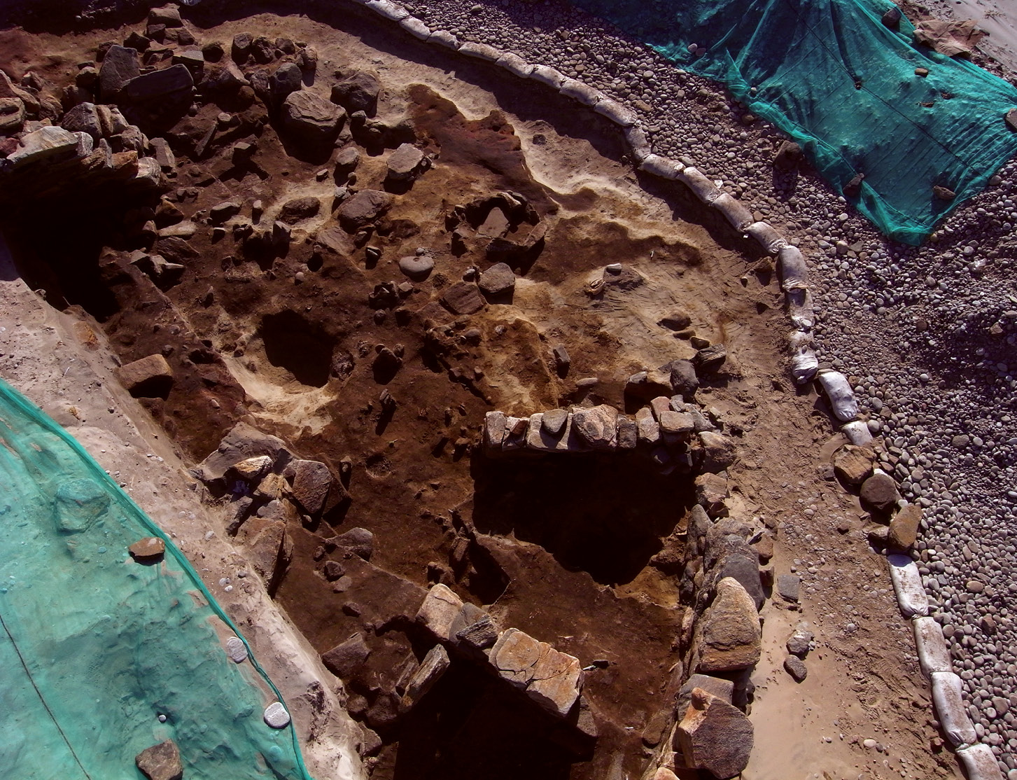 BELOW An Iron Age wheelhouse excavated on Baile Sear with (inset) a large hearth decorated with a cross that was created by running three fingers over wet clay.