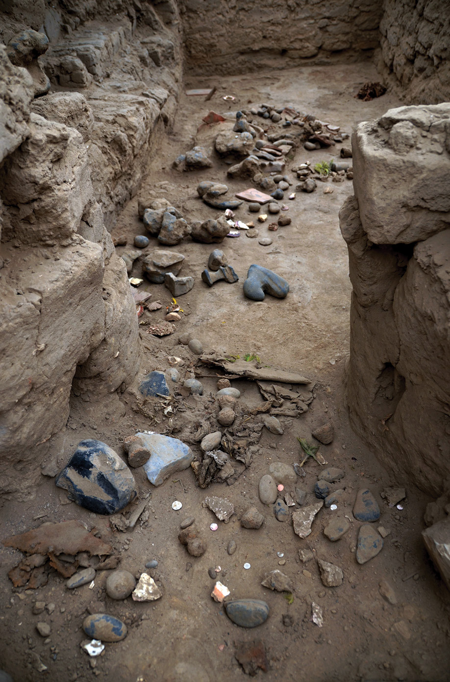 below The floor of the corridors and rooms of B15 were covered with hundreds of offerings left on the spot during an abandonment ceremony conducted shortly after the Spanish conquest. The artefacts deposited here included a miniature headdress and a painted textile. The headdress (below left) is part of a crown and is decorated with a turquoise feather mosaic of the Cotinga cayana bird (a sparrow species), and the green colour of the Ara severa bird (an Ara species). Both species come from Amazonia. The textile (bottom left) represents a mythical being half-animal, half-man with a large crescent headdress. It is typical of the Sicán culture, which existed more than 800km away from Pachacamac.