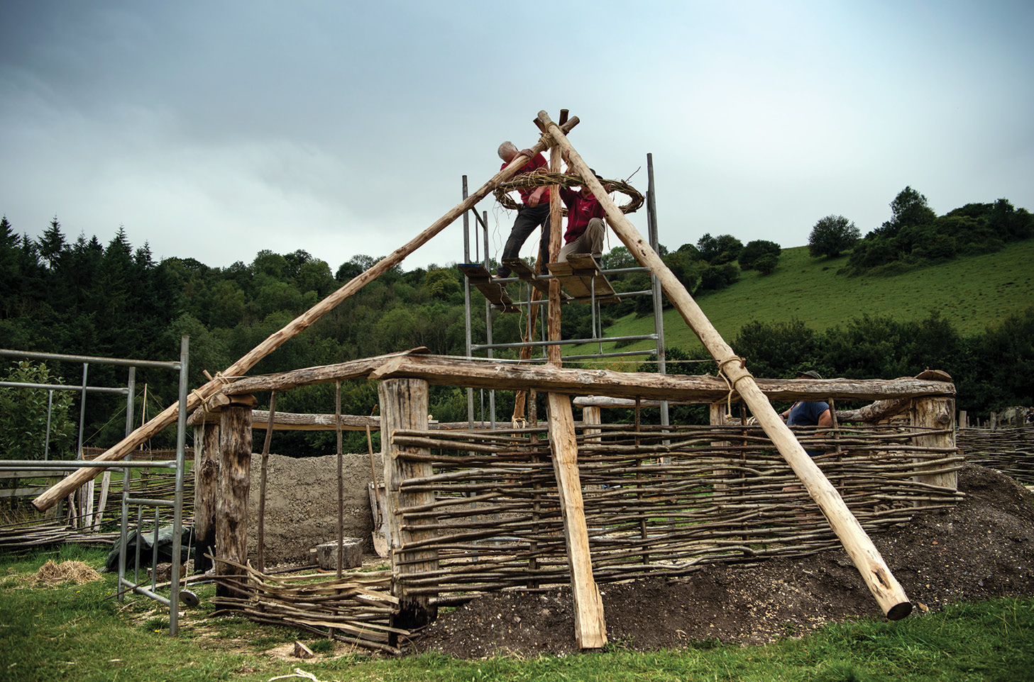 left & below Raising the rafters into position, and the roof’s thatchwork under way.