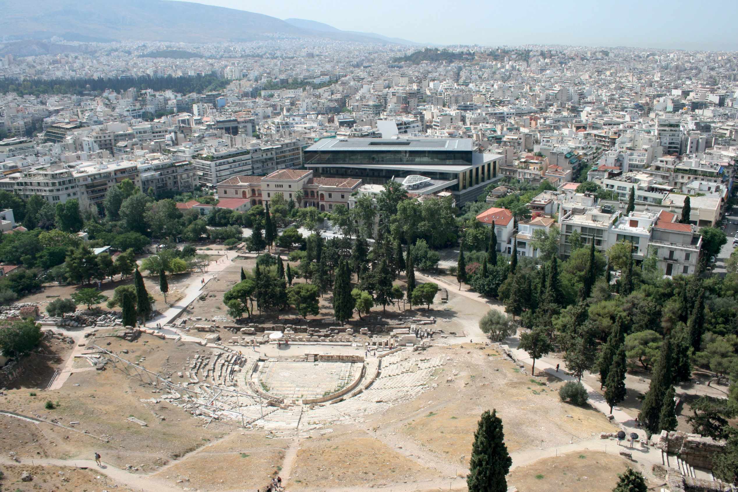 4. In Athens, looking down southwards from the Acropolis, with the Theatre of Dionysus in the foreground, and the new Acropolis Museum behind it. 5. Members of the Patrick Leigh Fermor Society approach the entrance to a tholos (beehive-shaped) tomb at Mycenae, which was excavated by Heinrich Schliemann in 1876.