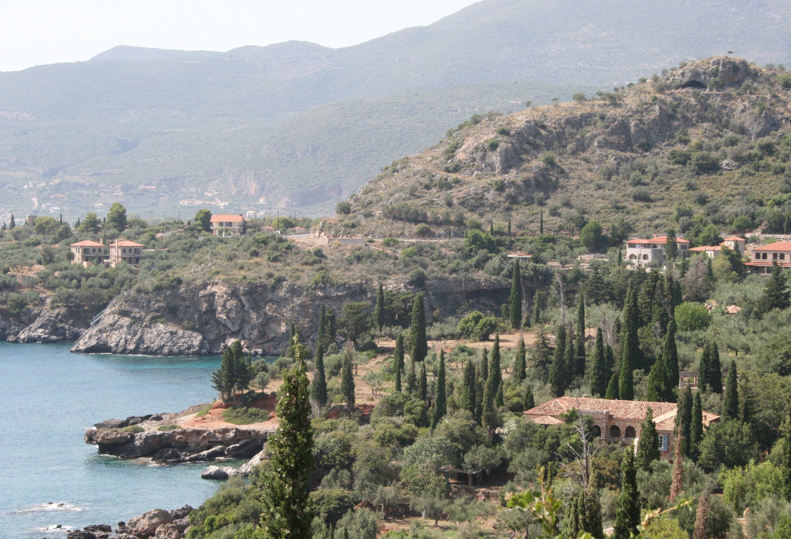 9. A view of Kardamyli on the Mani Peninsula Paddy Leigh Fermor’s house can be seen at the bottom right. 10. Fortified houses in Areopoli, the capital city of the Mani, and a Bofors anti-aircraft gun dating from the German occupation during the Second World War. 11. A closer view of Paddy’s house surrounded by olive groves and cypresses. © Benaki Museum. 12. A Classical corner stone, topped by Byzantine brickwork, rests on an even older boulder at the church of Agios Nikolaos, at Exochori near Kardamyli. 13. The church of Agios Nikolaos where Paddy scattered the ashes of his fellow travel writer, Bruce Chatwin. All photographs © Dominic Green unless otherwise marked.