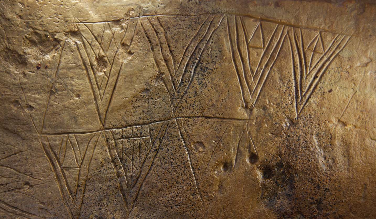 below A carved stone from Structure 10 at the Ness of Brodgar (the wider site is shown bottom). Similar geometric designs are found across Britain and Ireland on a range of materials, constructions, and objects.