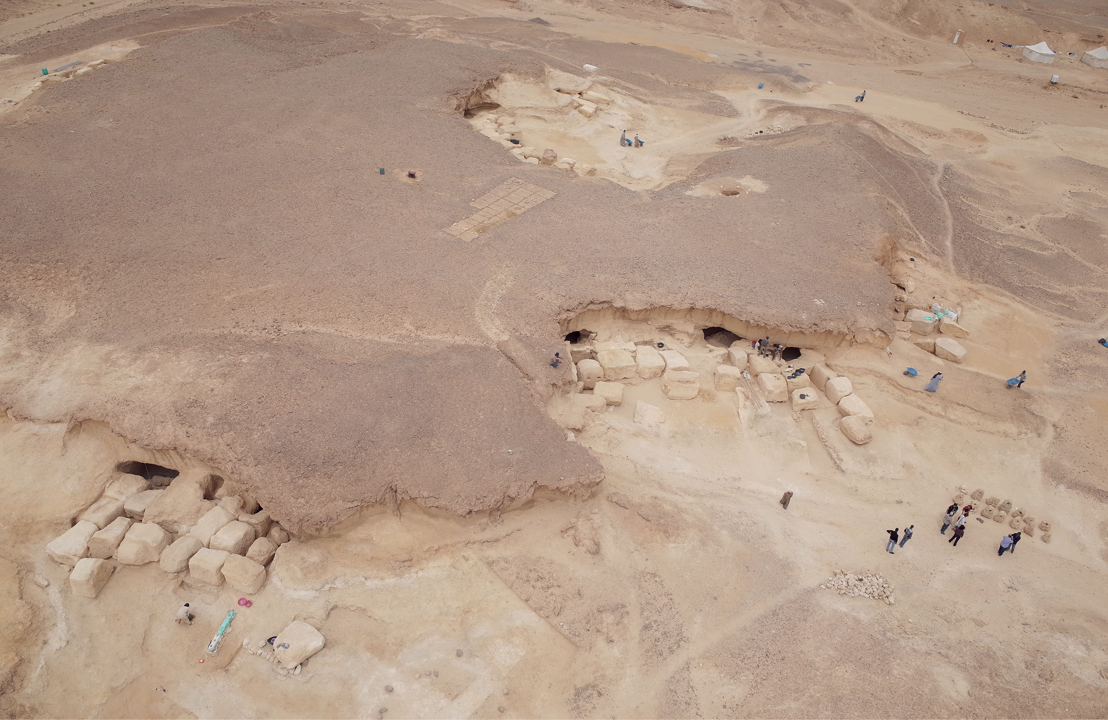 A view of the rock-cut galleries at Wadi el-Jarf, as photographed using a kite (above). Galleries G1 and G2 are visible to the left, while G4-G6 can be seen centre right. Massive limestone blocks were used to seal the galleries. This image (left) shows the entrance to storage galleries G1 and G2 after excavation. It was in a pit between blocks associated with G1 that the papyri were found.