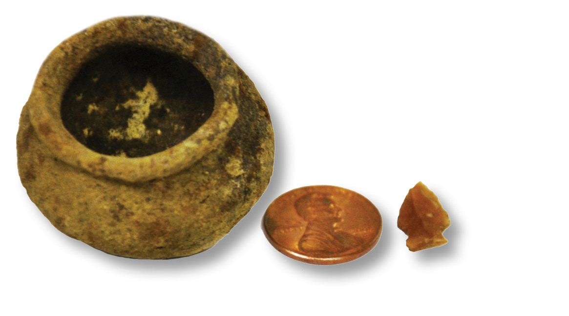 left A miniature pot and arrowhead, flanking a 1¢ piece for scale.