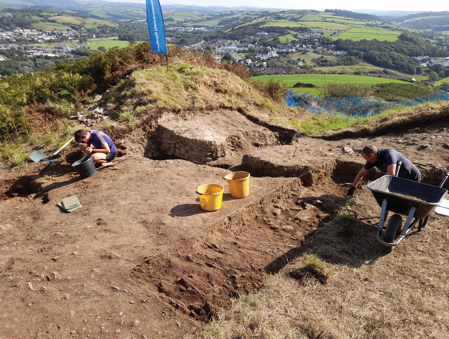 below Dyfed Archaeological Trust excavating the hillfort on Pen Dinas in 2021.The fortifications are located on an easily defended coastal hill near Aberystwyth.