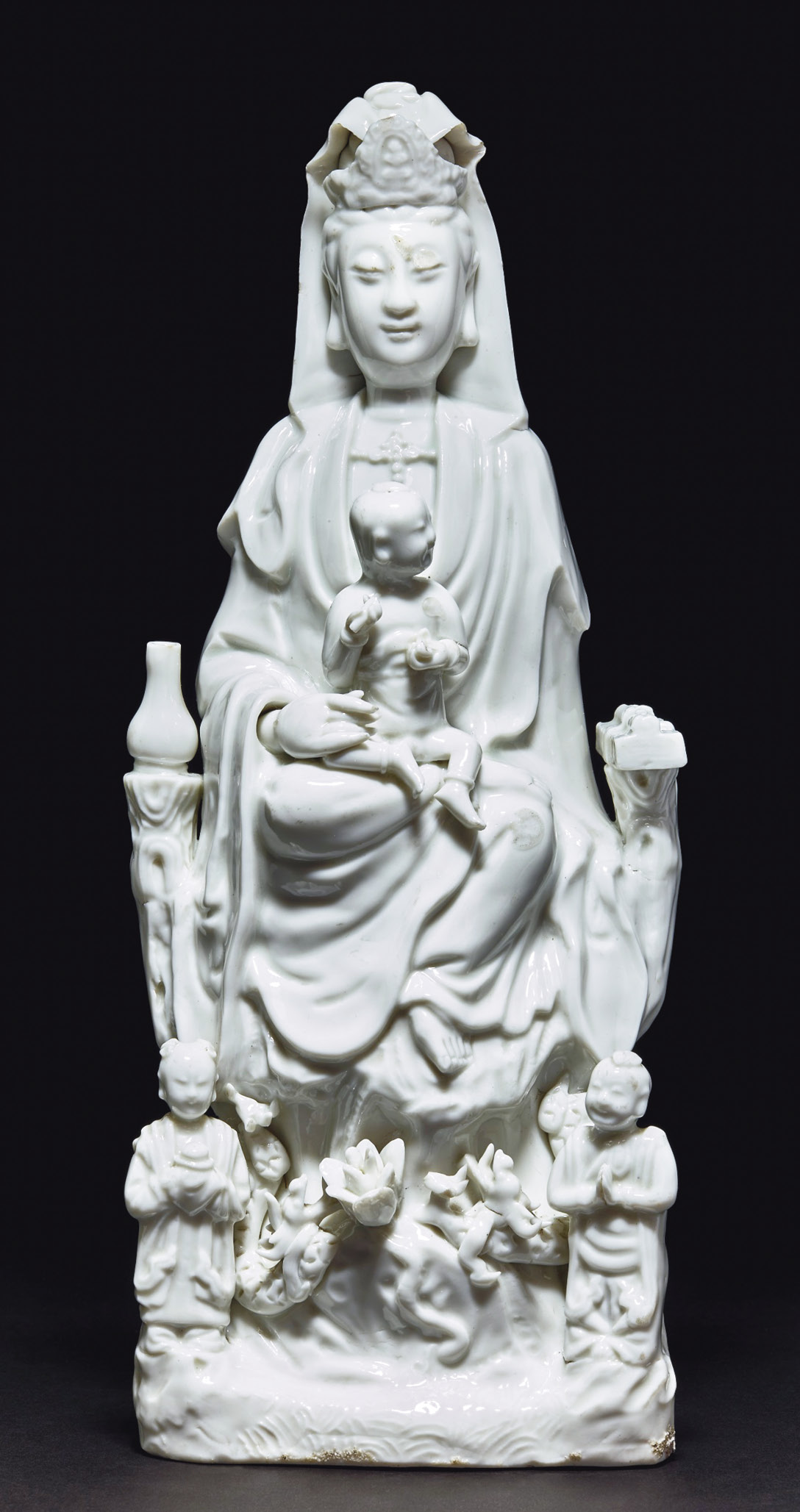 ABOVE Figure of Guanyin enthroned with child and attendants. Porcelain; China, 18th century. Size: 37.7 x 16.3 x 10.2cm