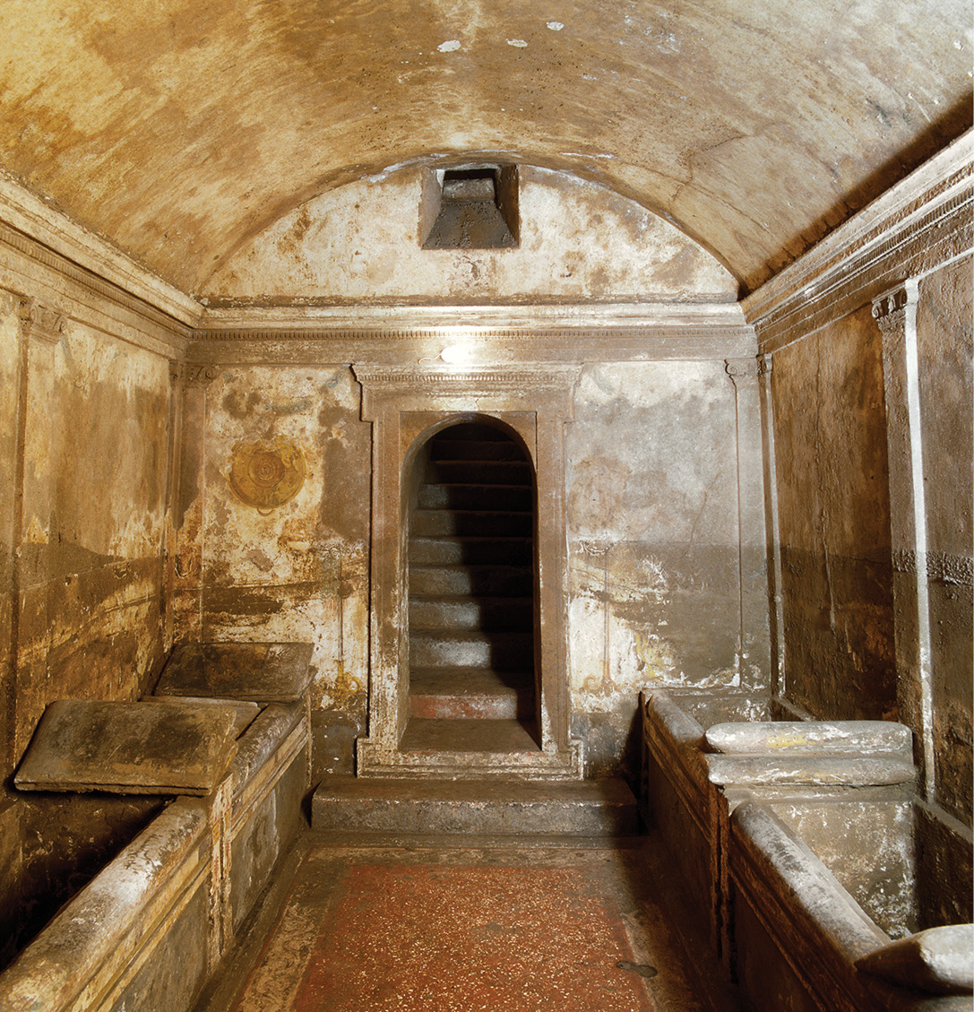 above Stone funerary beds line the sides of Hypogeum C of the Ipogeo. To the left of the door is a golden patera, painted as if hanging from the wall. left These funerary beds were brightly painted, as seen in this detail.