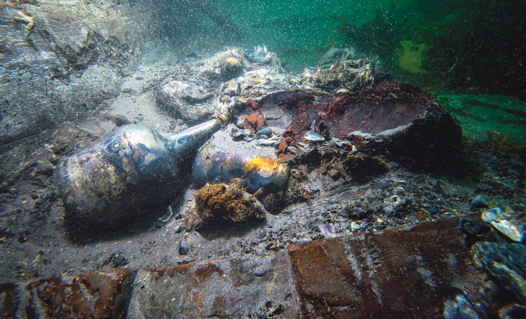 Many of the recovered objects reflect the food and drink that was consumed on the Invincible, such as this 18th-century bottle (left) shown on the wreck site together with a decidedly more 20th-century drink container and an intact glass onion bottle (below).