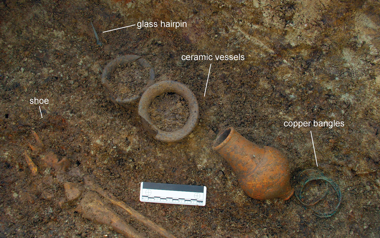 below One adolescent (aged 16-19) was buried with a silver chain around their neck (right). Outside their coffin, at the foot of the grave, was a large collection of personal items, including three pottery vessels, four copper-alloy bangles, and a glass