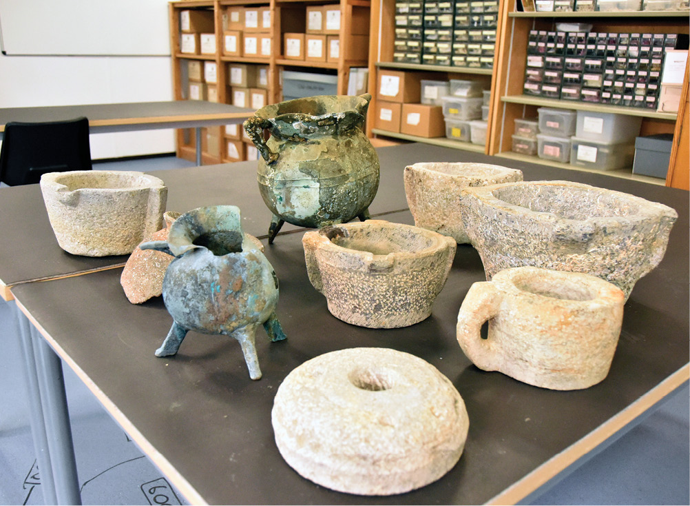 right A diver examines one of the decorated gravestones that the 13th-century Mortar Wreck vessel had been carrying at the time it sank. below Cauldrons, mortars, and other objects recovered from the wreck.