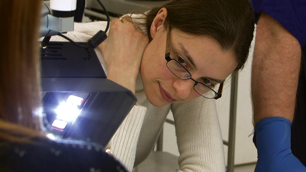 ABOVE Jo Appleby, the osteologist for the project, uses a crime light to examine the skeleton.