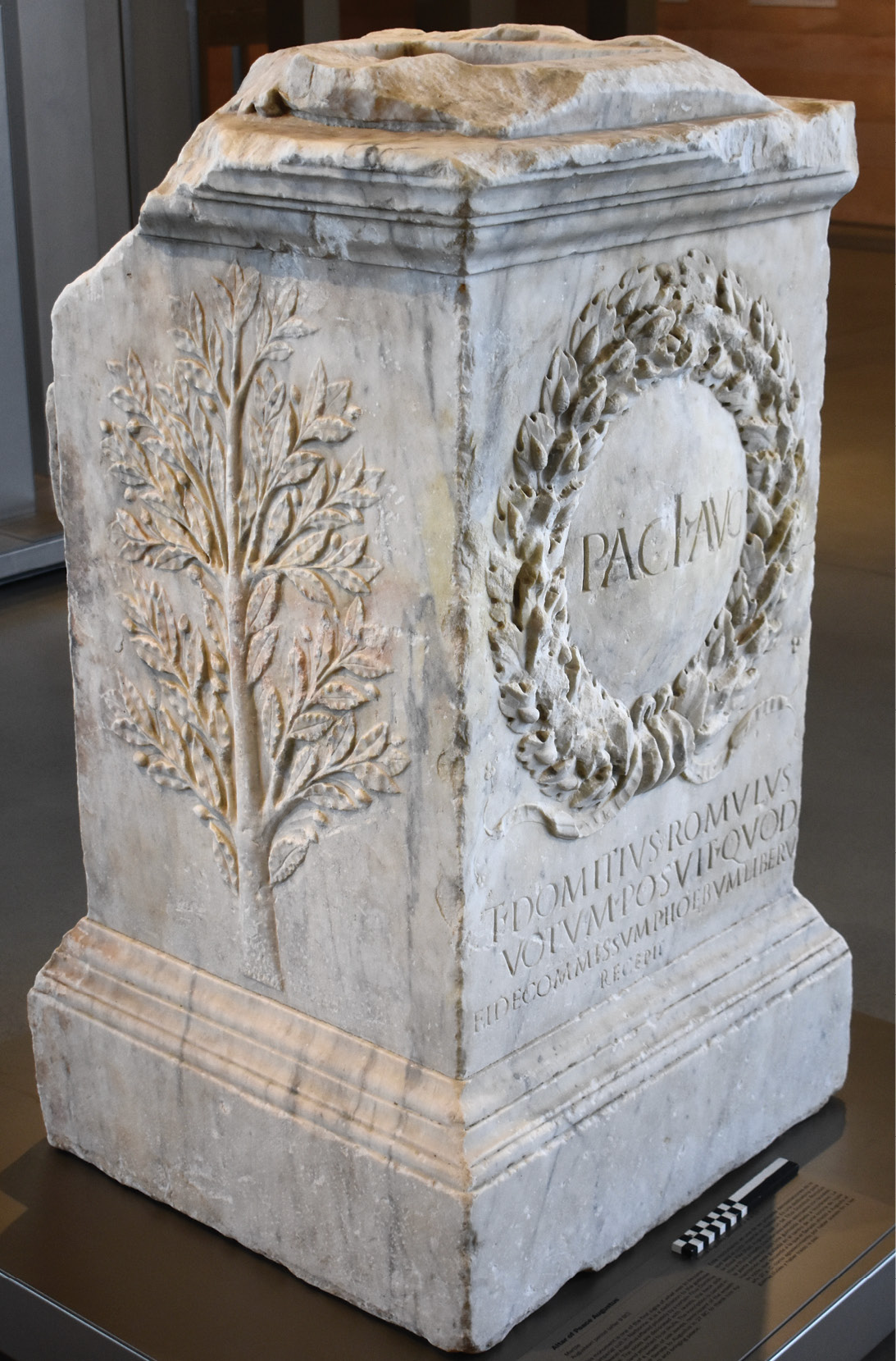 below Marble altar dedicated to the Augustan Peace, after 13 BC, by one Titus Domitius Romulus. The oak wreath alludes to that presented in Rome by the Senate to Augustus in 27 BC for ending the civil wars. (The scale shows 20cm.)