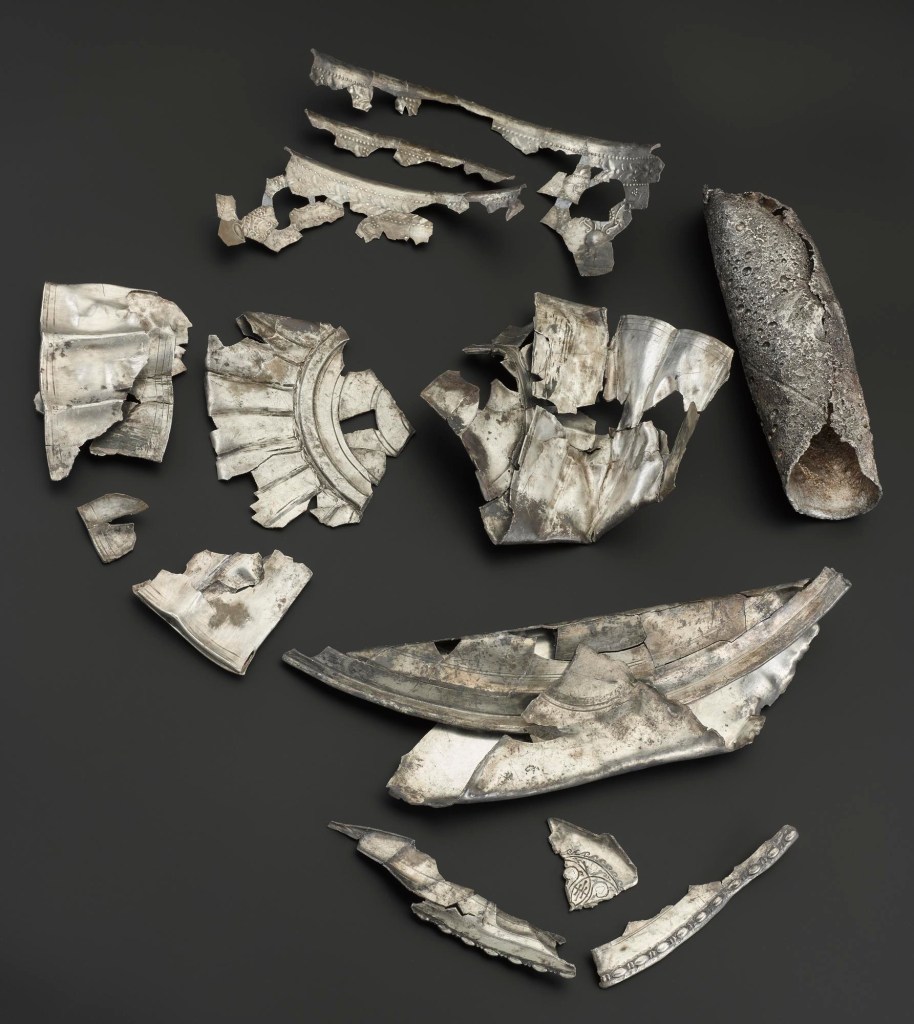 The hoard, pieced together as far as possible. One of the more enigmatic elements was a silver cylinder, shown to the right in this image.