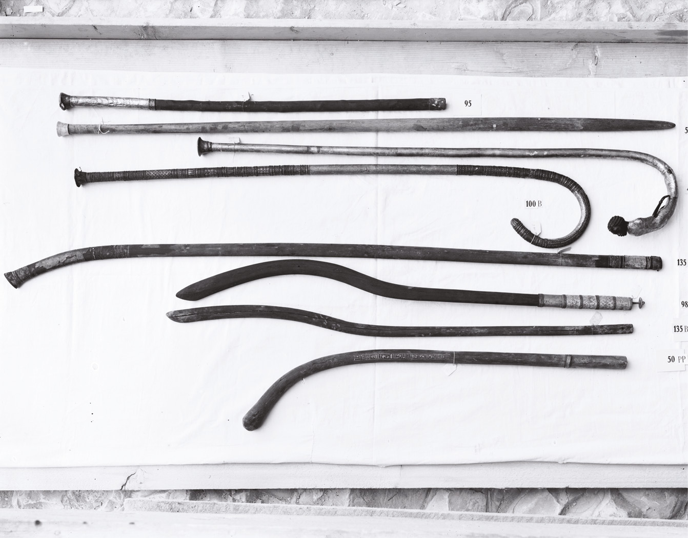 below Tutankhamun was buried with many ‘walking sticks’ or staves some of which are shown in this image taken by Harry Burton. However, such items were symbols of authority not evidence for a severe disability. bottom A pair of Tutankhamun’s sandals with images of defeated enemies who would be crushed underfoot as the king walked. Recent examination has not revealed any signs of adverse wear that would indicate the king suffered from a foot deformity.