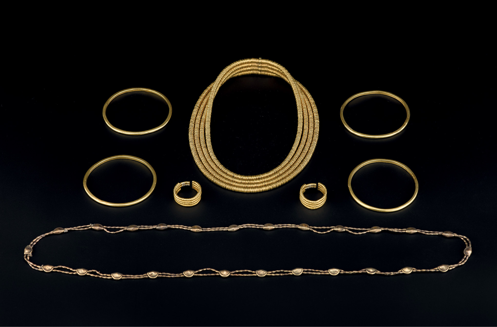 ABOVE The woman’s gold necklace, earrings, and bangles, and electrum girdle. Although the necklace and earrings went into the burial new or little used, the bangles appear to have been used, while the girdle may have been an heirloom. LEFT A close-up of the damaged inscription on the coffin of the ‘Qurna Queen’. RIGHT These gold necklace clasps were recycled as stand-ins for earrings for the child.