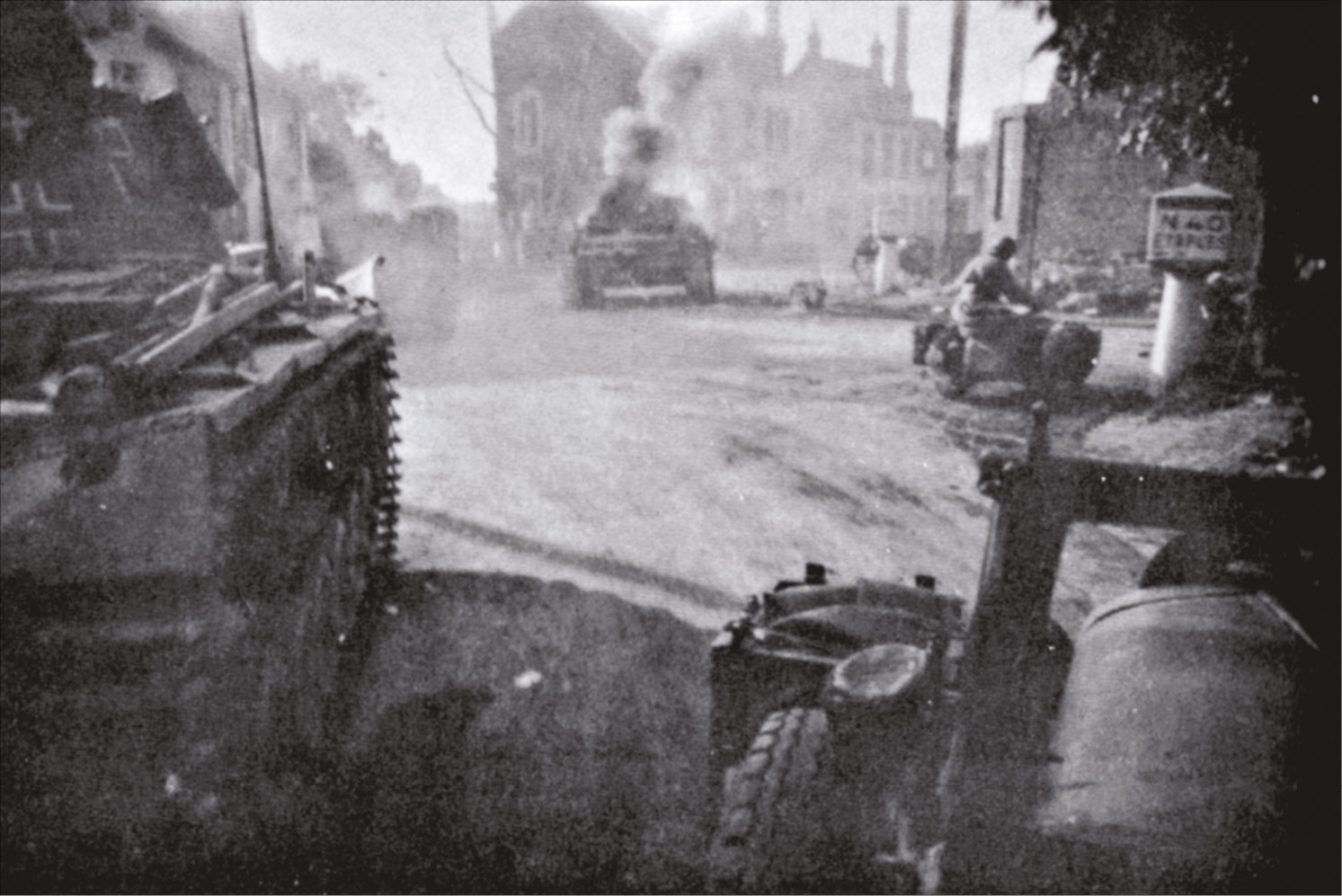 LEft A German tank from the 2nd (Vienna) Panzer Division is knocked out at a village intersection on 23 May, as the battle group commanded by Heinrich von Prittwitz und Gaffron battled its way into Boulogne from the south. below left Heavily flooded terrain, such as this along the main axis of attack of the German 18th Infantry Division towards Bergues and Dunkirk, effectively denied the attacking German forces access to the Dunkirk pocket in strength. bottom LEFT German soldiers advance across a totally flat landscape. The axis of attack was always towards the billowing clouds of smoke bubbling up from the blazing refineries at Dunkirk.