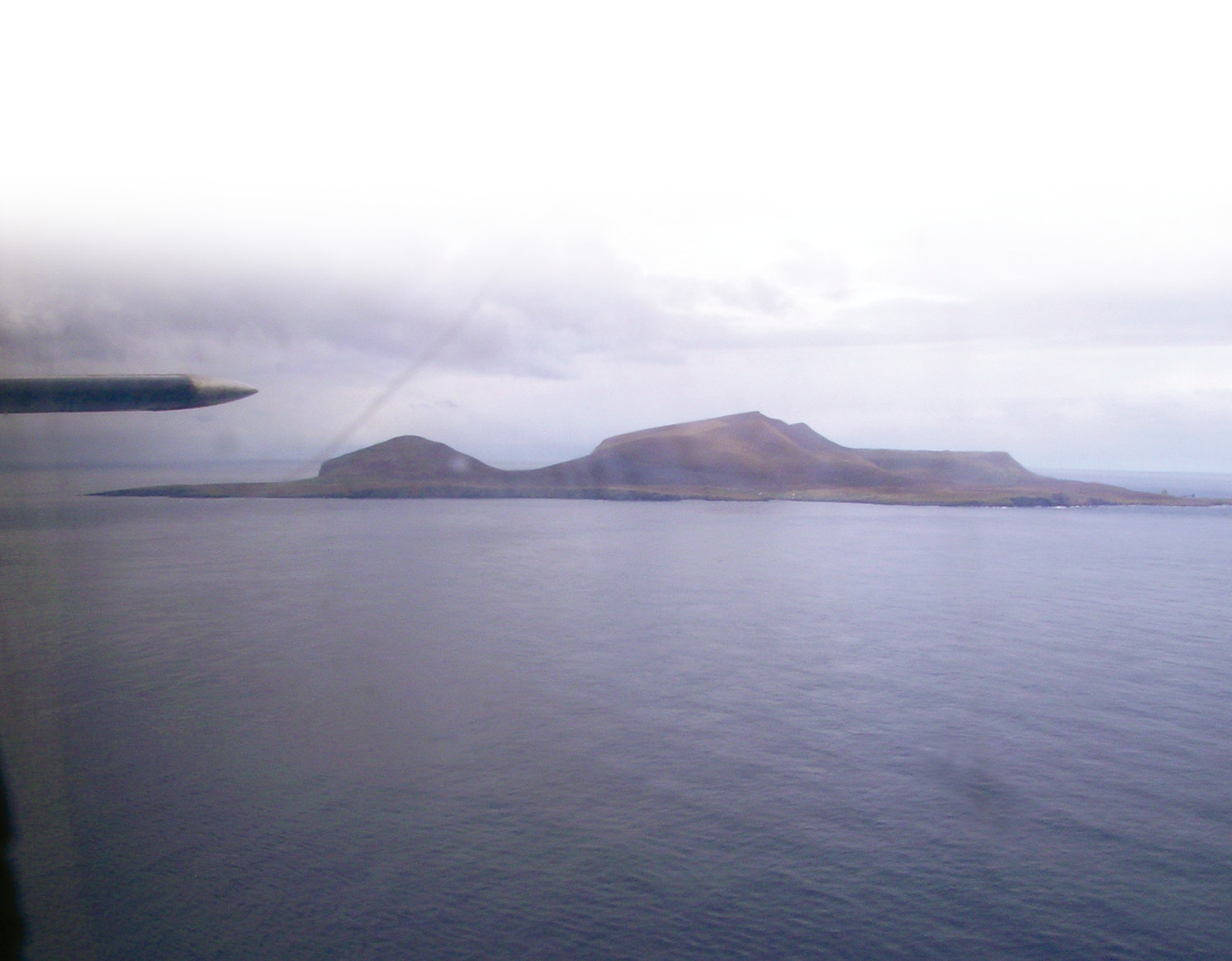 Below Foula from the air. Less than three miles by two, the whole west of the island is mountainous. The stone ring discovered by the Bath and Camerton team sits on the ridge at the north of the island, where the mountains fall away (right of picture).