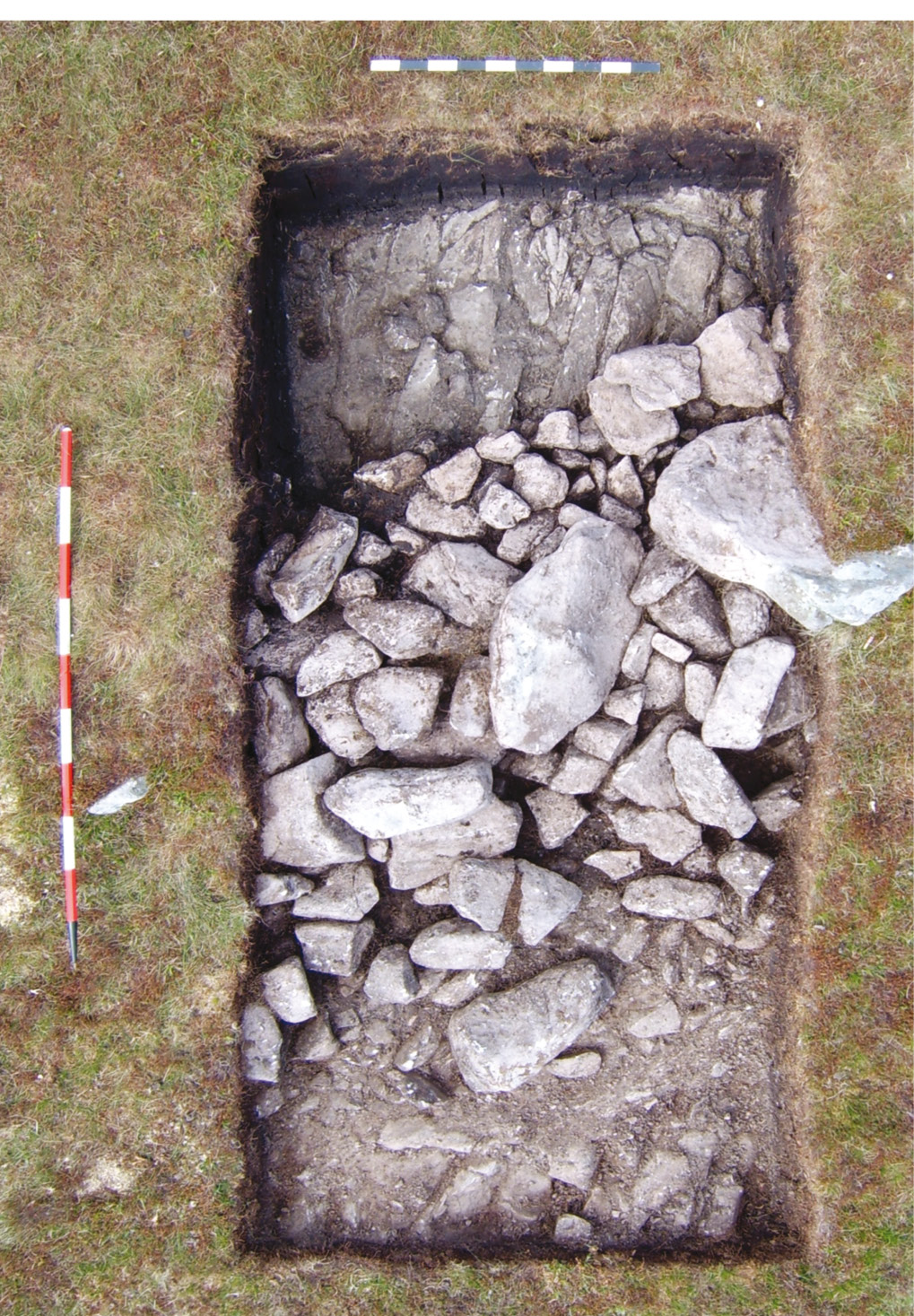 Above left Trench A taken from overhead, using a camera on a 6m-high pole (North to the top). Two toppled stones and their stone footings can be seen, with bedrock showing either side. Above right Excavation has revealed the stone footings that hold this upright stone in its place.