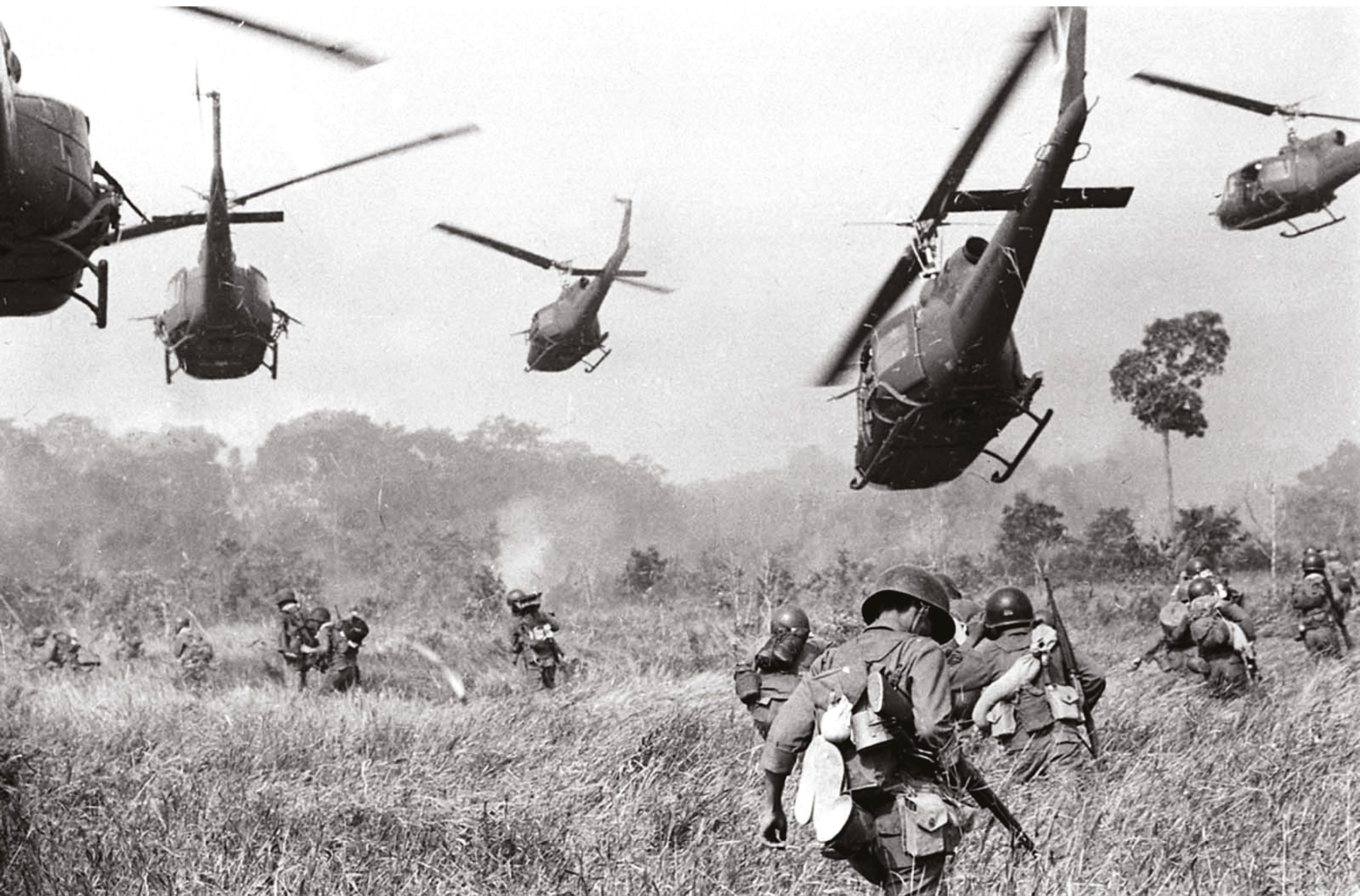 Below US Army helicopters pour machine-gun fire into a tree-line to cover the advance of South Vietnamese ground troops in an attack on a Viet Cong camp near the Cambodian border, March 1965.